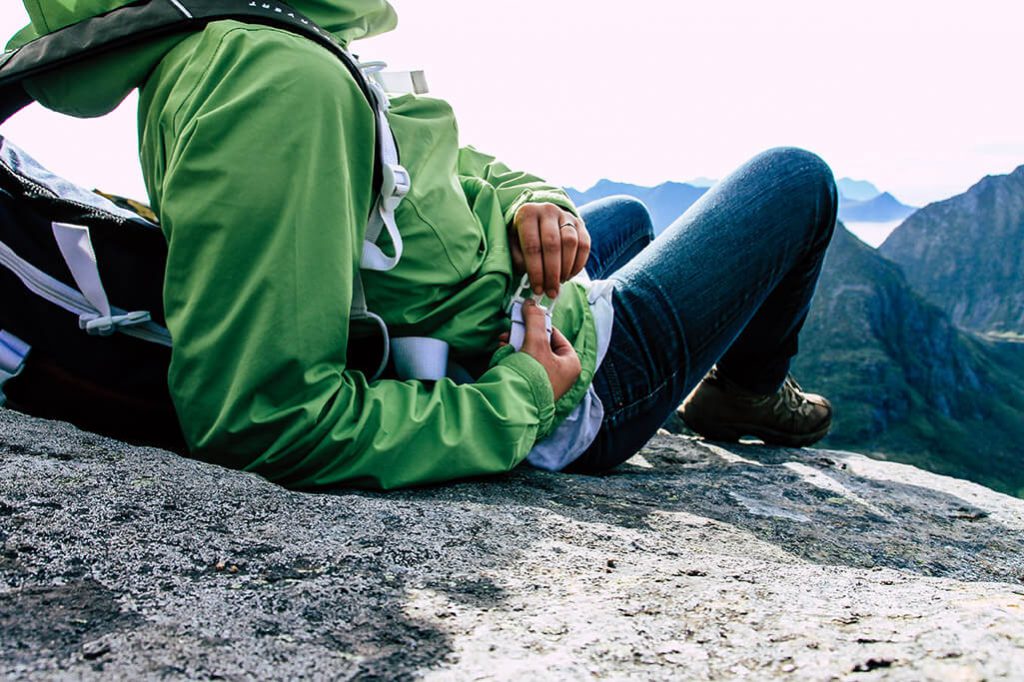 Person sitzt auf Felsblock und geniesst Aussicht