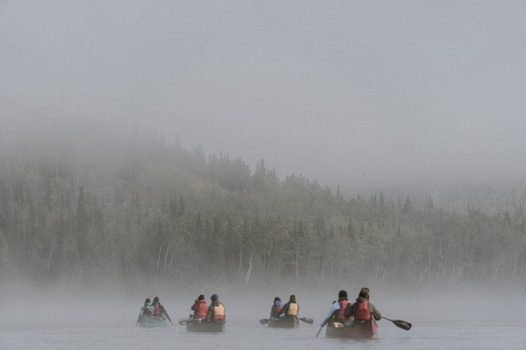 Mehrere farbige Kanus im Morgennebel auf dem Yukon Fluss