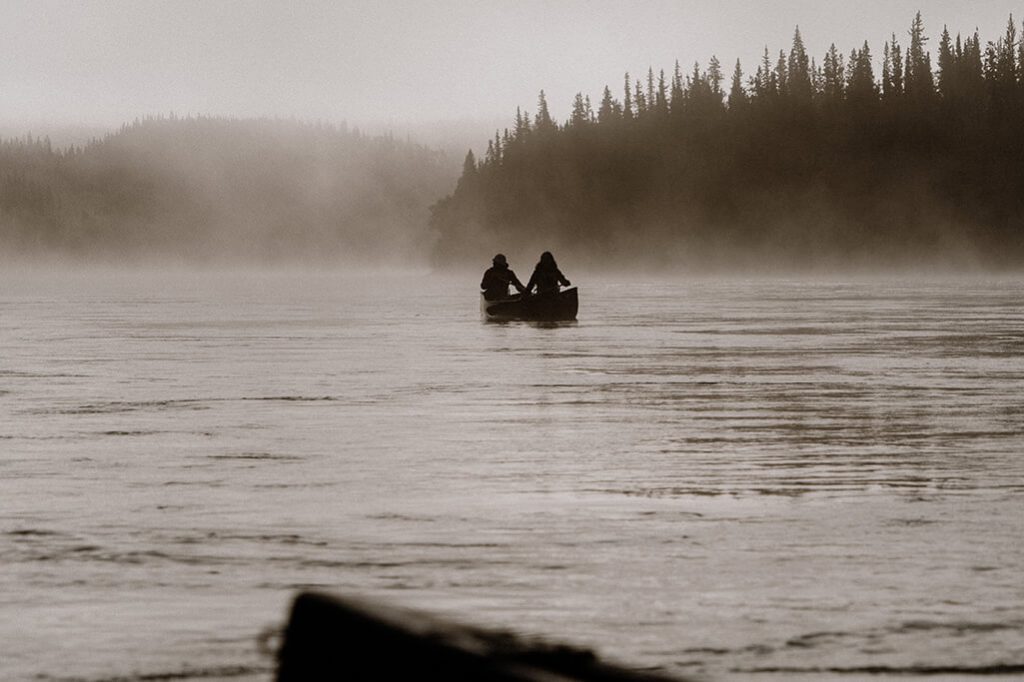 Sonnenaufgang mit Kanu und Morgennebel am Yukon Fluss