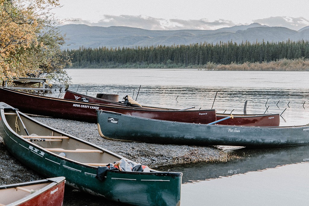 Abenddämmerung am Yukon Fluss, mit auf's Ufer gezogenen Kanus.