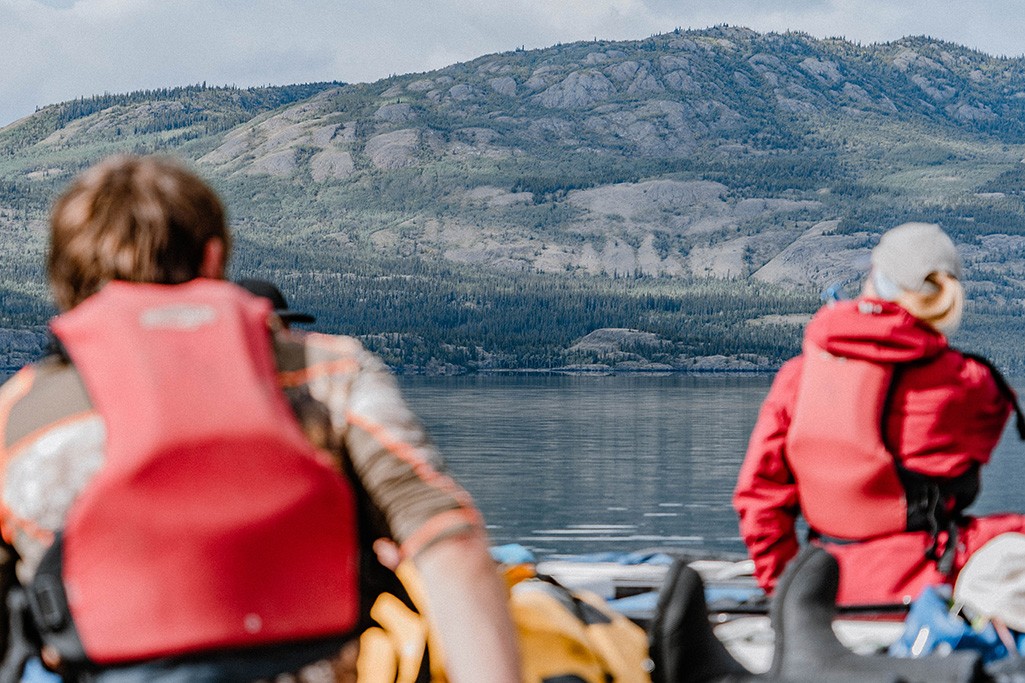 geführte Yukon Kanutour mit Ruby Range Adventure, Kanufahrer im Vordergrund, Landschaft im Hintergrund