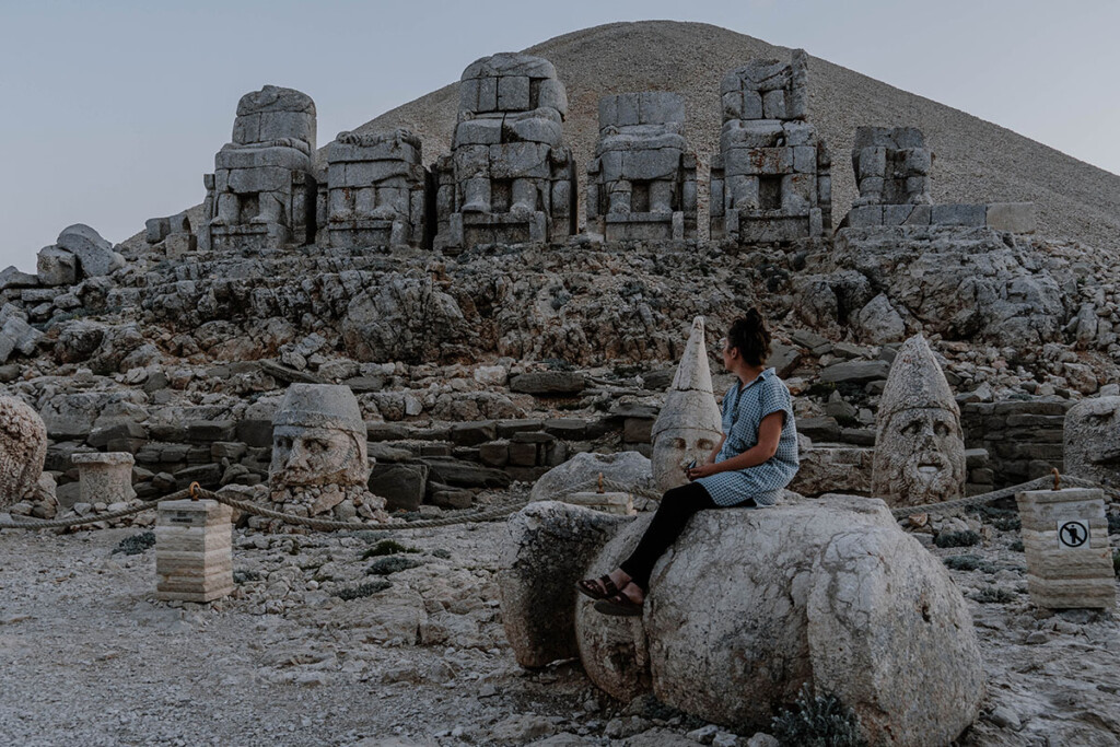 Elisa Model vom Camping Blog take an adVANture sitzt auf Stein einer Ausgrabungsstätte in der Türkei.