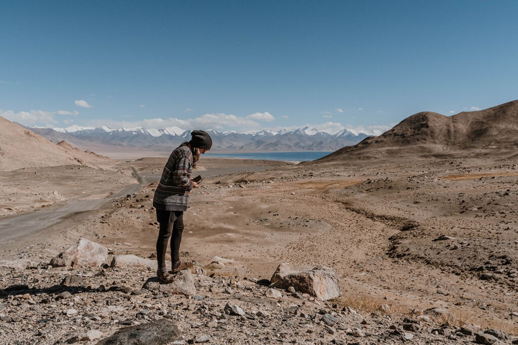 Elisa Model vom Camping Blog 'take an adVANture' steht oberhalb vom See Karakul und blickt zur Seite.