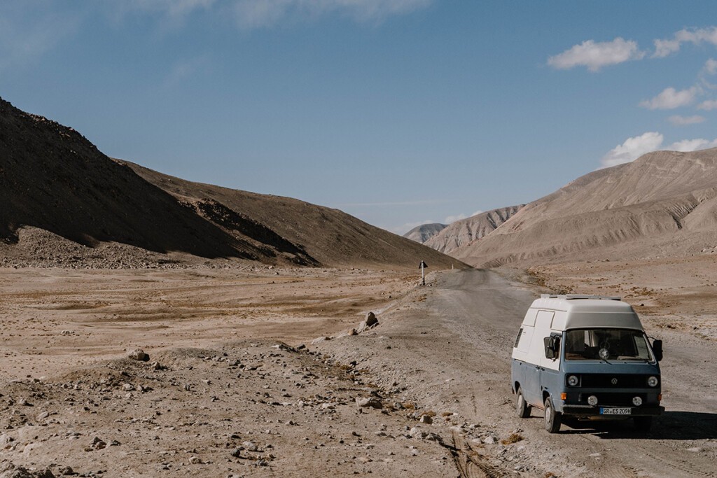 Blau-weißer VW T3 Postbus steht am Rand vom Pamir-Highway.