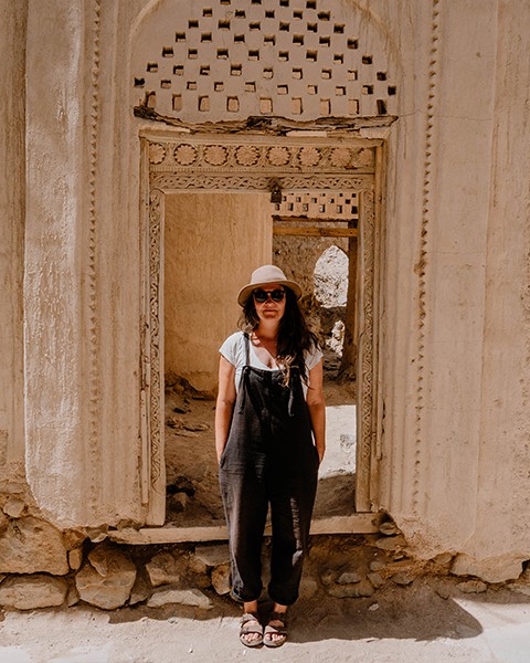 Elisa Model vom Camping Blog take an adVANture steht in Türrahmen vor altem Lehmhaus.