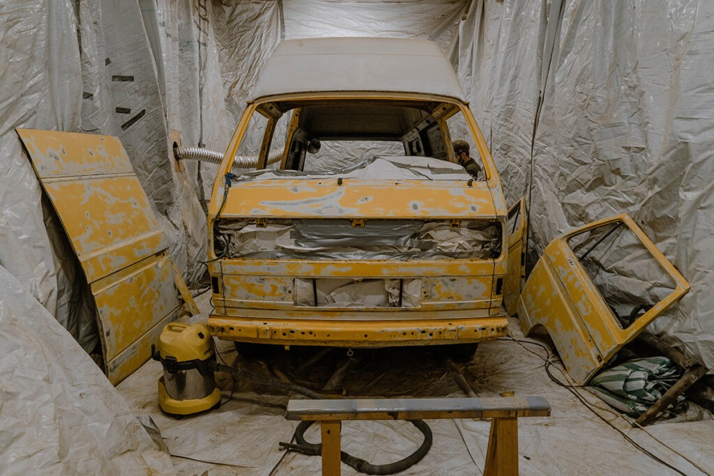 VW T3 Postbus in Lackierkabine mit ausgebauten Scheiben, ausgebauter Front und ausgebauten Türen.