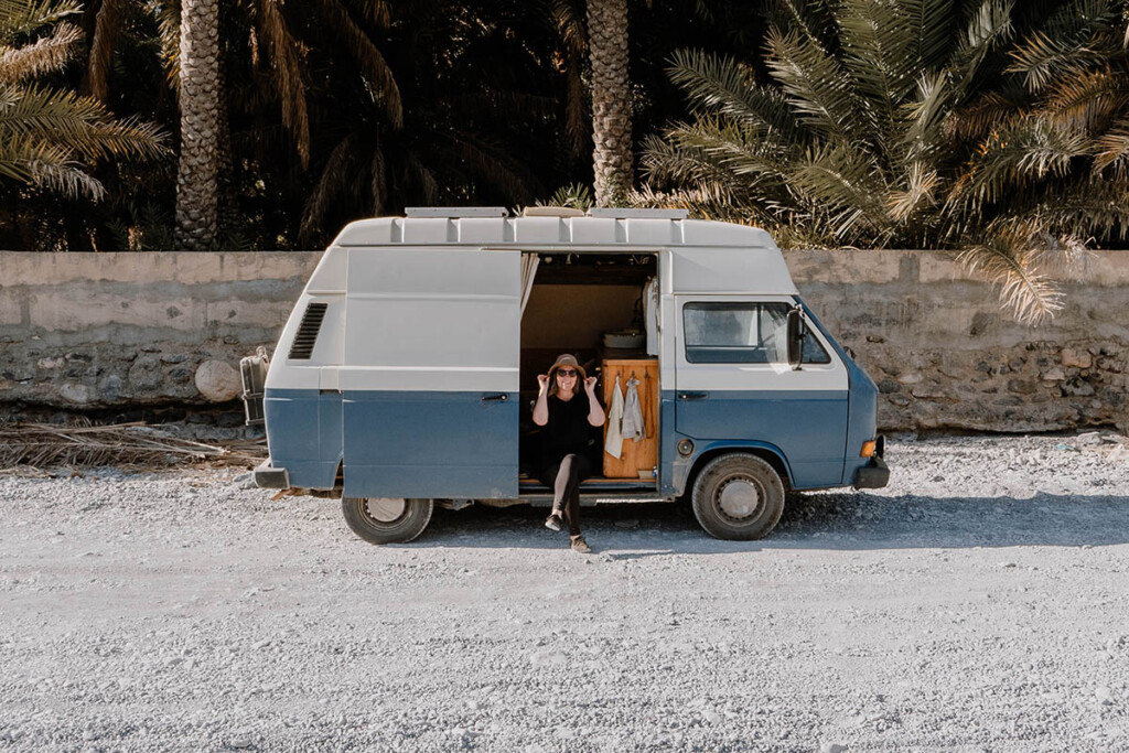 Elisa Model vom Camping Blog take an adVANture sitzt in der geöffneten Schiebetür von ihrem VW T3 Camper.