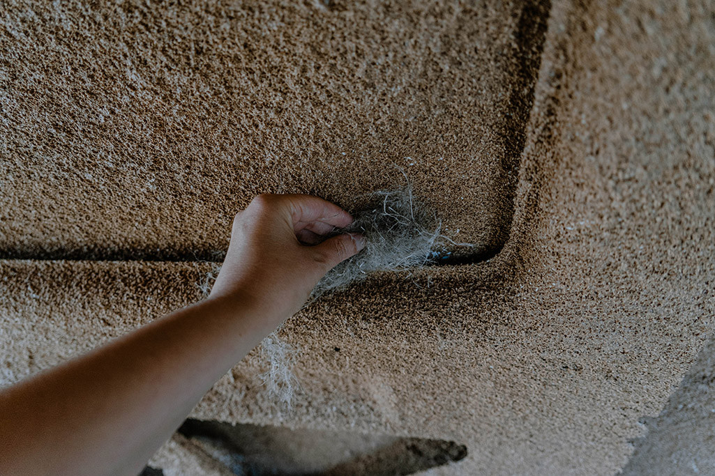 Person stopft Stopfhanf in die Holme von einem Wohnmobil.