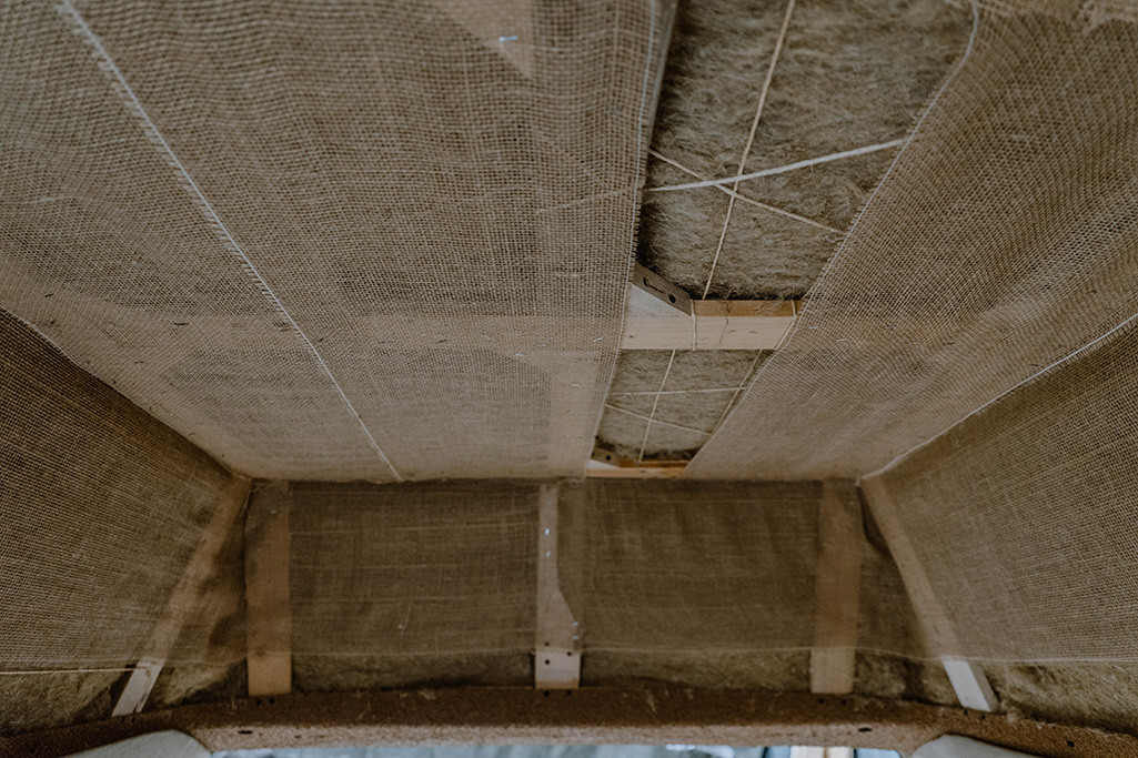 Fast vollständig auf Unterkonstruktion angebrachtes Jutegewebe als Blickschutz zur natürlichen Dämmung im Camper.