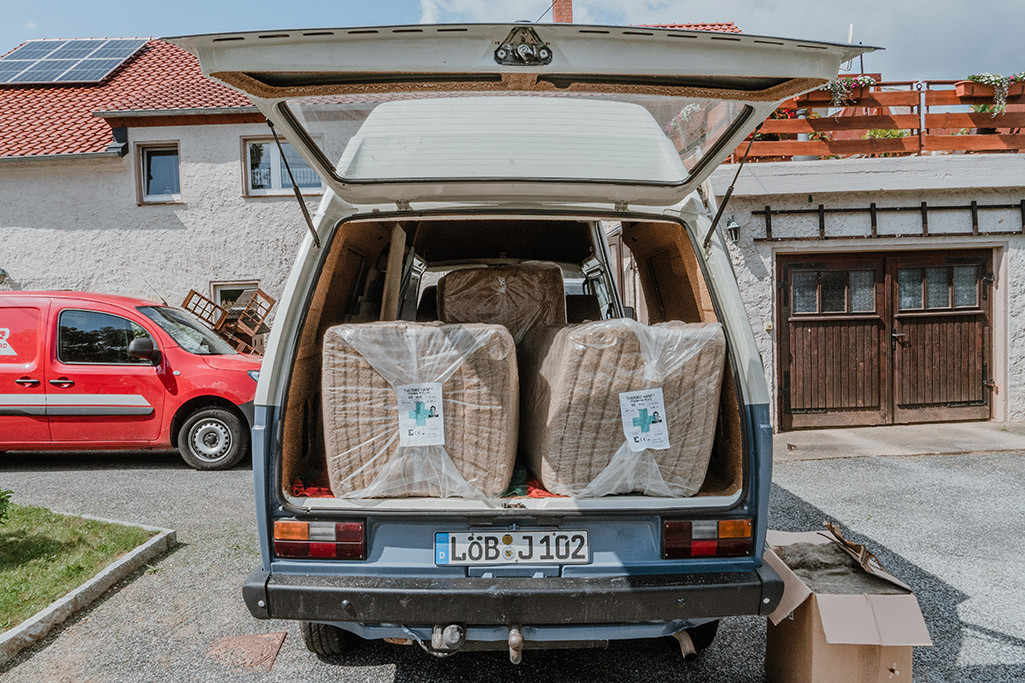 Hanfdämmung Wohnmobil: Aufgeklappte Heckklappe von VW T3 mit 3 Paketen Hanfdämmung im Inneren.