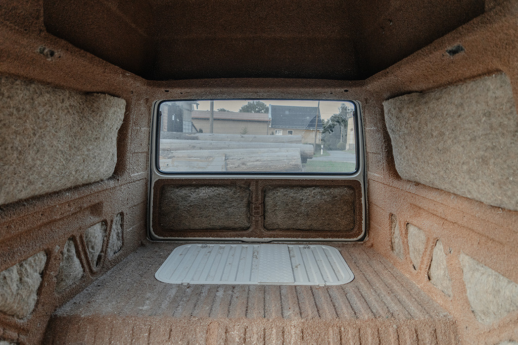 An den Wänden angebrachte Hanfdämmung im VW T3 Camper - von vorne nach hinten in den unausgebauten, leeren Innenraum fotografiert.