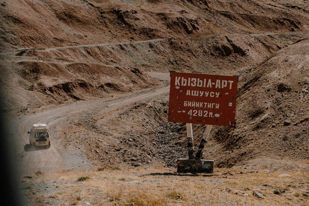 Schild mit kyrillischen Buchstaben, dass den Kyzyl-Art-Pass und dessen Höhe ankündigt.
