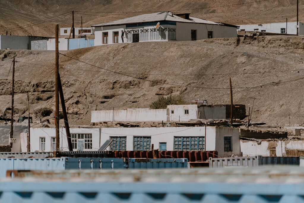 Blick über den Container-Bazaar auf Häuser aus Stein am Hang in Murgab.