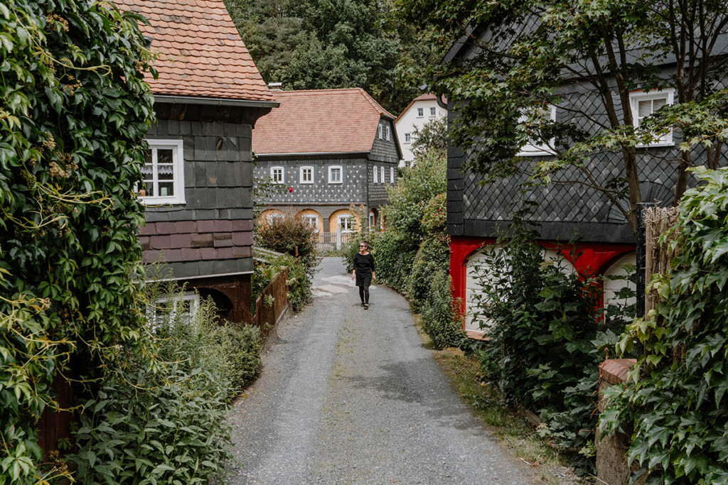 Person spaziert durch den Denkmalort Obercunnersdorf in der Oberlausitz.