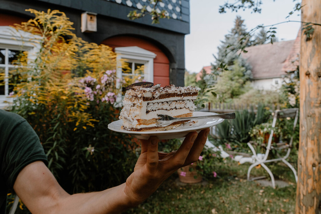 Person hält Teller mit Kuchen im Café Brumme in Obercunnersdorf.
