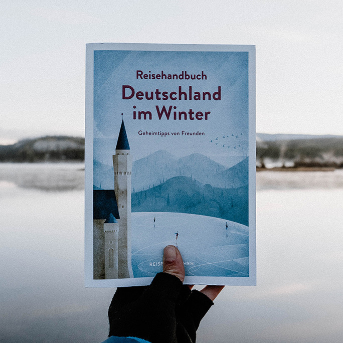 Person hält Reisehandbuch 