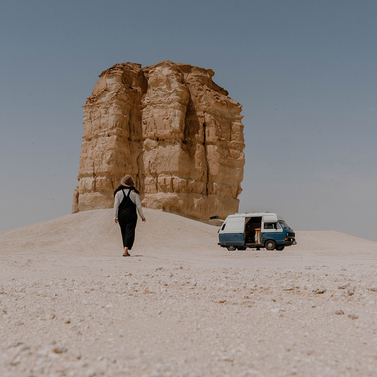 Elisa Model vom Camping Blog take an adVANture mit ihrem selbstausgebauten VW T3 Camper vor Felsen in Saudi-Arabien.